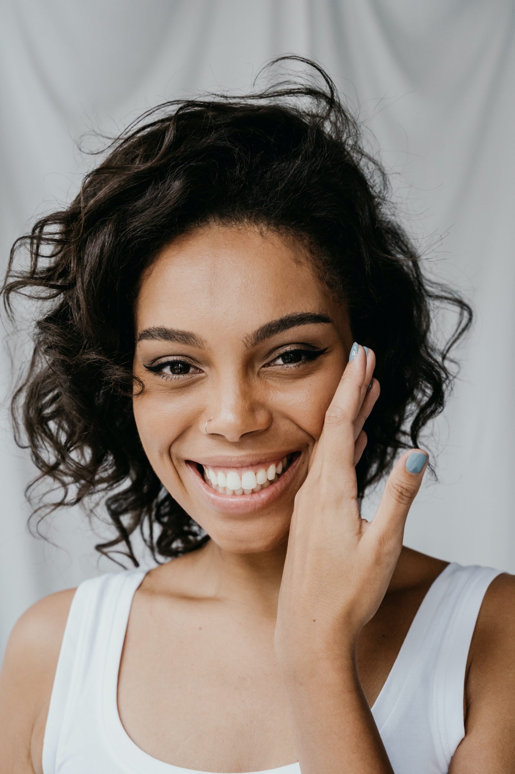 beautiful black woman smiling holding her face