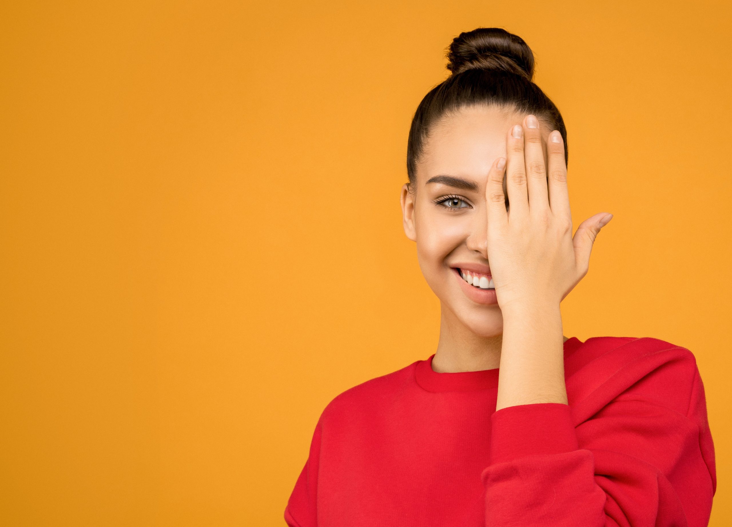 woman wearing a red sweater on orange background